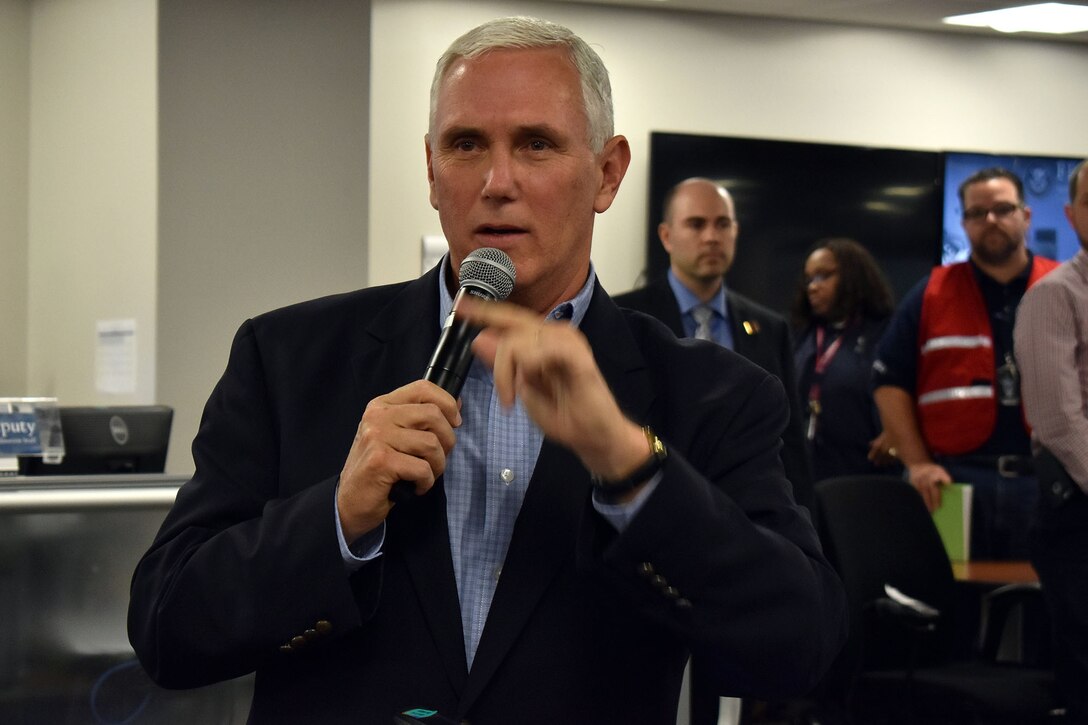 The vice president holds a microphone and talks.