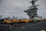 Chief selects run in formation during an Applied Suicide Intervention Skills Training 5k run on the flight deck of the aircraft carrier USS Theodore Roosevelt