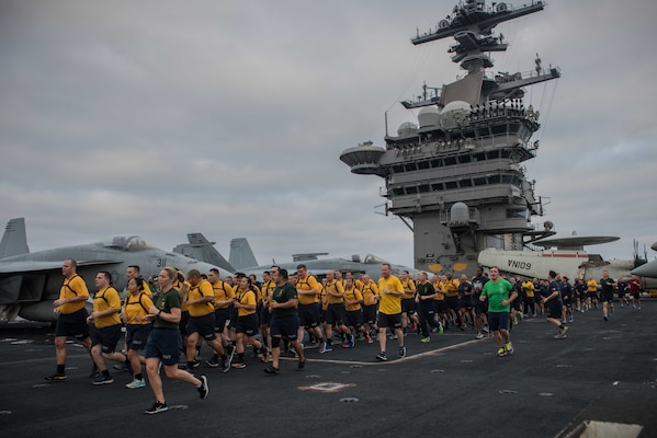 PACIFIC OCEAN (Aug. 17, 2017) Chief selects run in formation during an Applied Suicide Intervention Skills Training (ASIST) 5k run on the flight deck of the aircraft carrier USS Theodore Roosevelt (CVN 71). Theodore Roosevelt is underway conducting a composite training unit exercise (COMPTUEX) with its carrier strike group in preparation for an upcoming deployment. COMPTUEX tests a carrier strike group's mission readiness and ability to perform as an integrated unit through simulated real-world scenarios. (U.S. Navy photo by Mass Communication Specialist 3rd Class Alex Perlman/Released)