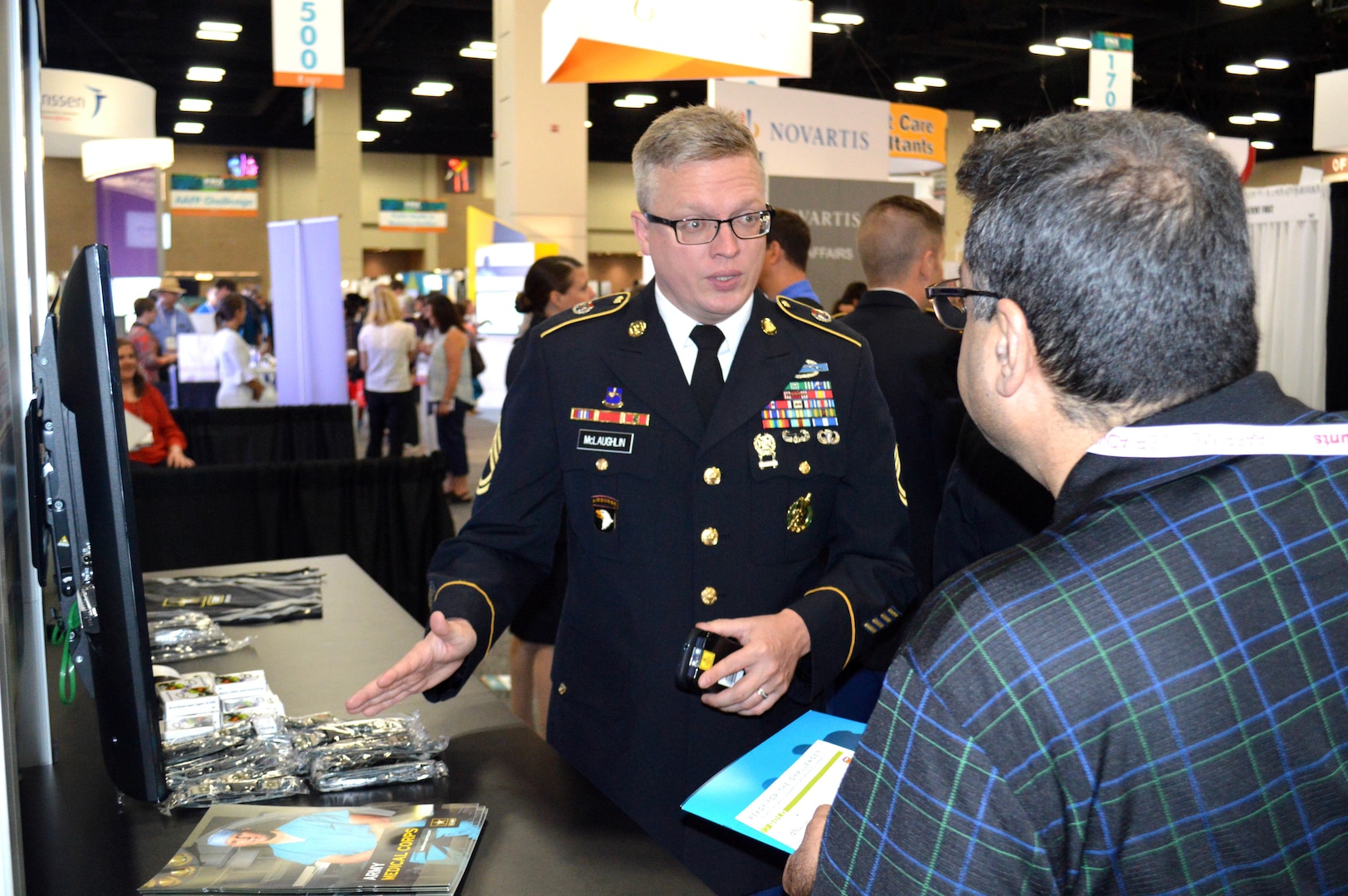 Army Sgt. 1st Class Chad McLaughlin, lead recruiter for the San Antonio Medical Recruiting Center, explains Army Medical Corps careers to an attendee of the American Academy of Family Physicians Family Medicine Experience 2017 or FMX 2017, Sept. 14 at the Henry B. Gonzales Convention Center in downtown San Antonio.
