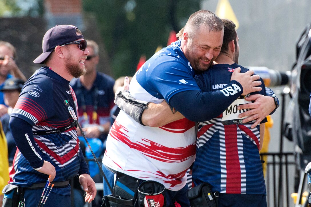 Sgt. Sean Hook, left, hugs a British competitor after competing in archery during the 2017 Invictus Games