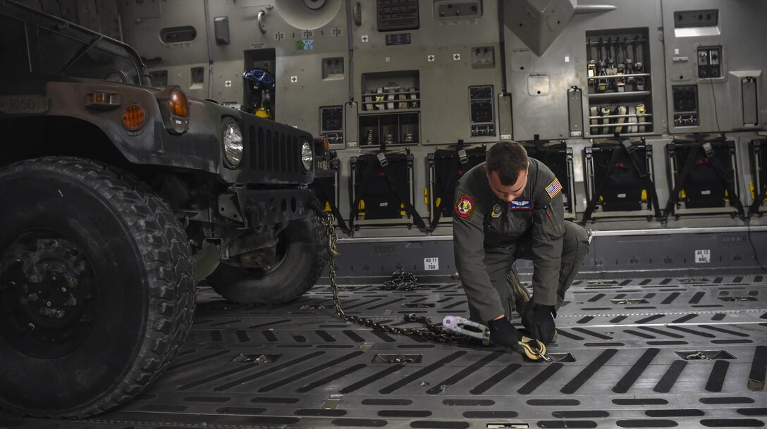 Airman 1st Class Patrick Schmidt, 15th Airlift Squadron loadmaster, secures a Humvee in the cargo bay of C-17 Globemaster III at Fort Drum, N.Y., Sept. 28th, 2017.