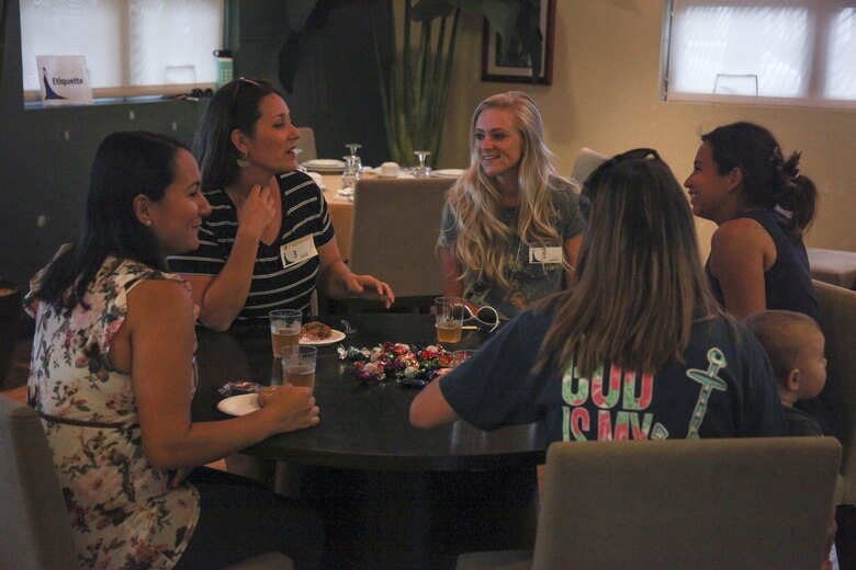 Military spouses with Marine Corps Base Hawaii (MCBH) socialize before a gown exchange fashion show starts at the Mololani Community Center, MCBH, Sept. 28, 2017.  The gown exchange and fashion show is an event for spouses to find new dresses for the 242nd Marine Corps Ball on a budget while learning ball etiquette and making friends. (U.S. Marine Corps Photo by Lance Cpl. Autumn Curlin)