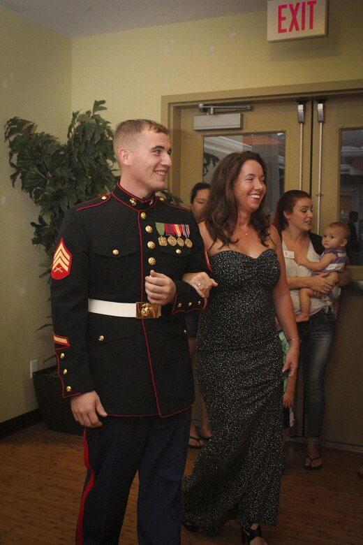 Michelle Elliot models a dress with her date during a gown exchange fashion show at the Mololani Community Center, Marine Corps Base Hawaii, Sept. 28, 2017.  The gown exchange and fashion show is an event for spouses to find new dresses for the 242nd Marine Corps Ball on a budget while learning ball etiquette and making friends. (U.S. Marine Corps Photo by Lance Cpl. Autumn Curlin)