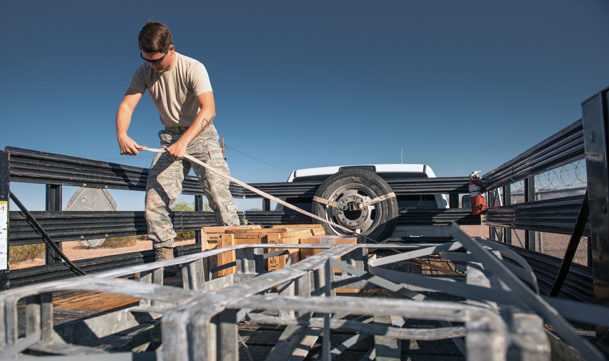 Senior Airman Ryan Gildehaus, 56th Civil Engineer Squadron explosive ordinance disposal team member, ties down explosives at the Barry M. Goldwater Range in Gila Bend, Ariz., Sept. 21, 2017. Before training, EOD Airmen loaded various test explosives onto their vehicles that were used on the range throughout the training day. (U.S. Air Force photo/Airman 1st Class Alexander Cook)