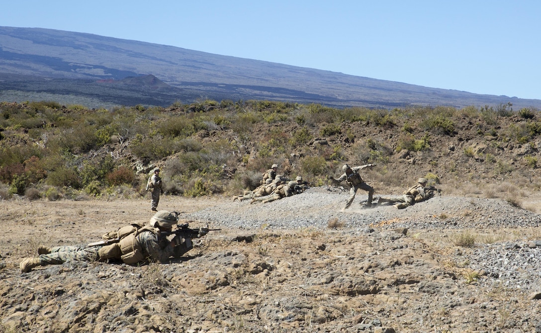 POHAKULOA TRAINING AREA, HAWAII -- A Marine with Kilo Company, 3rd Battalion, 3rd Marine Regiment, prepares to throw a grenade at the objective while his squad members provide suppression during a platoon live-fire event at Pohakuloa Training Area Aug. 22, 2017. The training event, a part of Exercise Bougainville II, consisted of a platoon-size force breaching through a concertina wire obstacle, then assaulting multiple enemy positions with notional support from 60 mm mortars and a machine gun emplacement. Exercise Bougainville II prepares 3rd Battalion, 3rd Marine Regiment for service as a forward deployed force in the Pacific by training them to fight as a ground combat element in a Marine Air-Ground Task Force. (U.S. Marine Corps photo by Lance Cpl. Luke Kuennen)