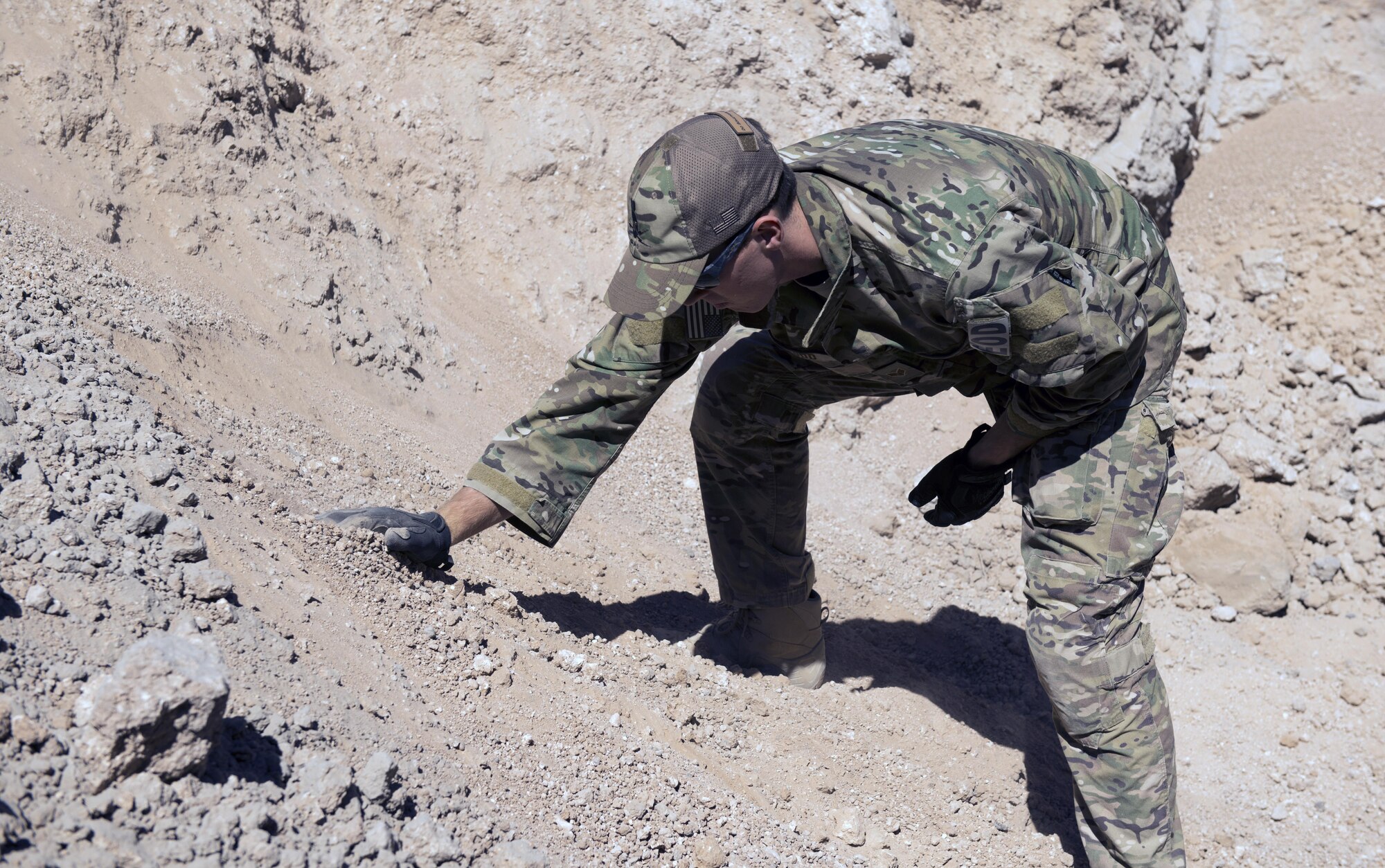 Senior Airman Tahir Finley, 56th Civil Engineer Squadron explosive ordinance disposal team member, searches for bomb fragments after a detonation at the Gila Bend Air Force Auxiliary Field in Gila Bend, Ariz., Sept. 21, 2017. After detonation, EOD Airmen look for remnants of fragments to see the effects caused by the explosion. (U.S. Air Force photo/Airman 1st Class Alexander Cook)