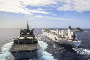 Three ships travel in the ocean.