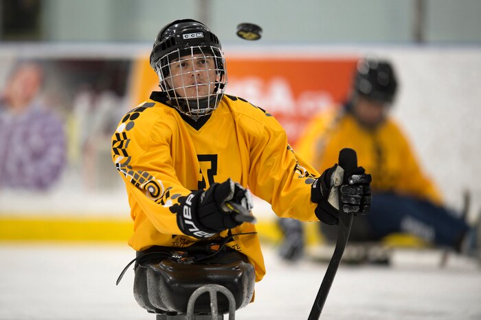 Marine Corps Sgt. Ivan Sears flips a puck during practice for a 2017 Invictus Games sledge hockey game.
