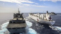 Three ships travel in the ocean.