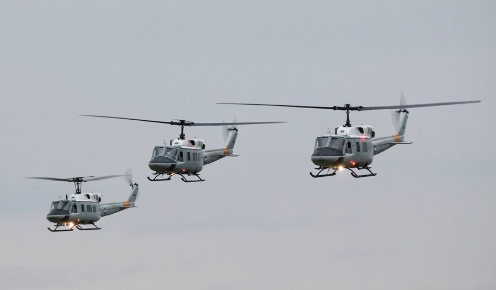 Three UH-1N Iroquois helicopters assigned to the 459th Airlift Squadron take off for a formation flight