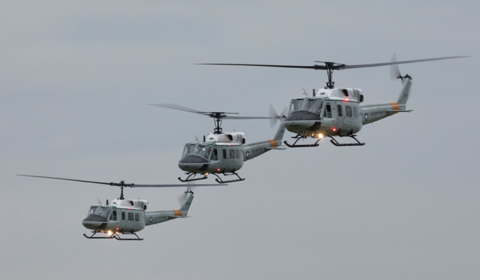 Three UH-1N Iroquois helicopters assigned to the 459th Airlift Squadron take off for a formation flight