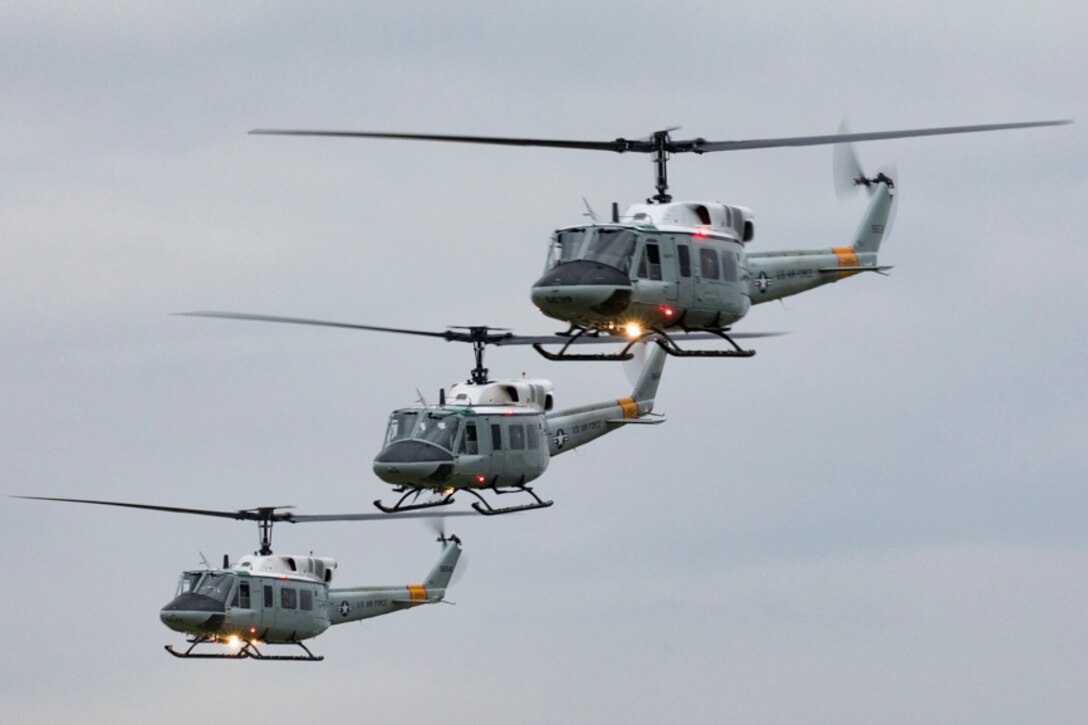 Three UH-1N Iroquois helicopters assigned to the 459th Airlift Squadron take off for a formation flight
