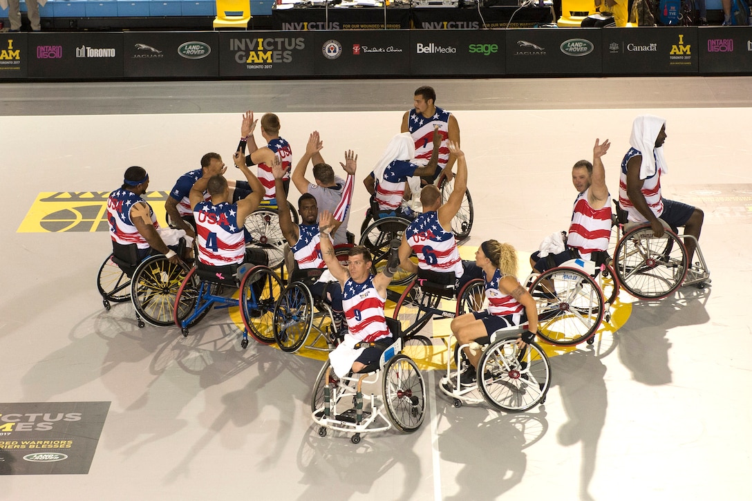 Team U.S. members celebrate a preliminary rounds wheelchair basketball game win during Invictus Games 2017.