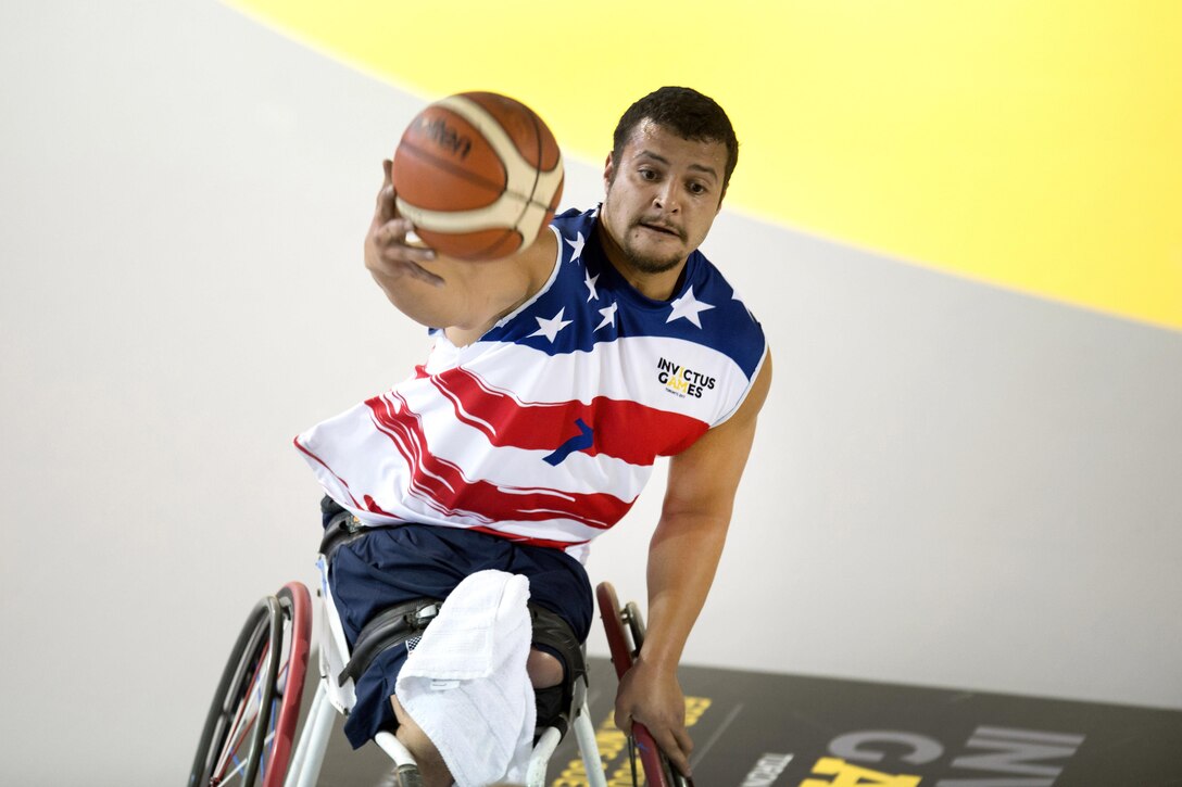 Marine Corps veteran Cpl. Jorge Salazar catches a pass against Netherland defenders in a preliminary rounds wheelchair basketball game