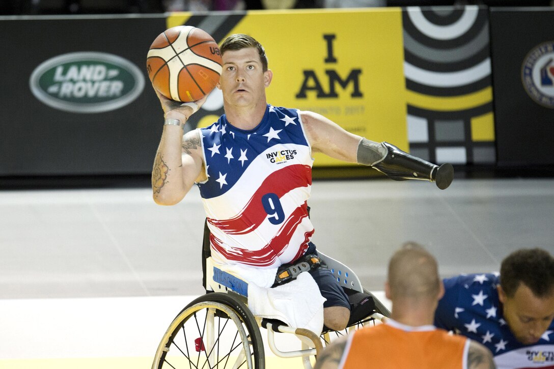 Marine Corp Sgt. Michael Nicholson takes a shot against Netherlands defenders in a preliminary rounds wheelchair basketball game.