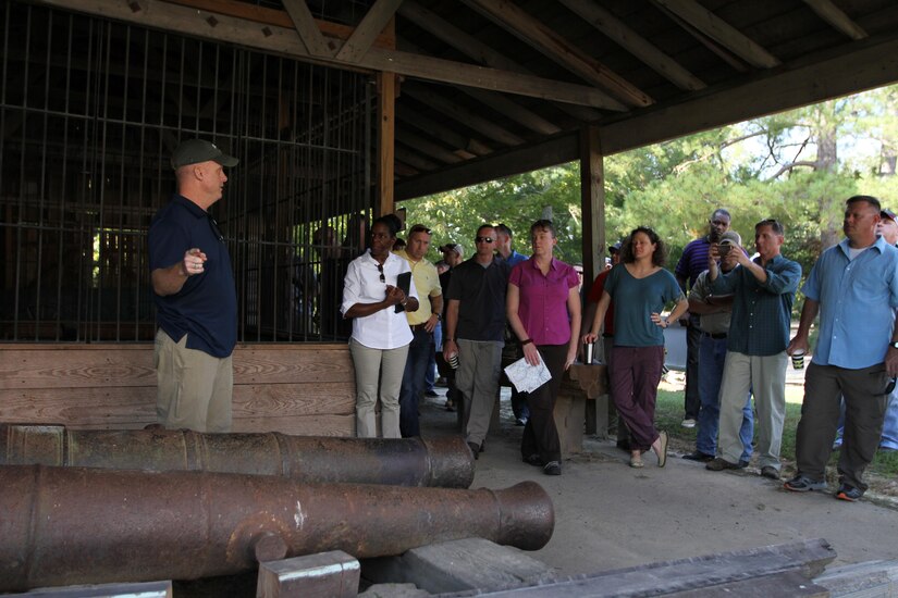 A group of people stand around two Revolutionary War cannons.