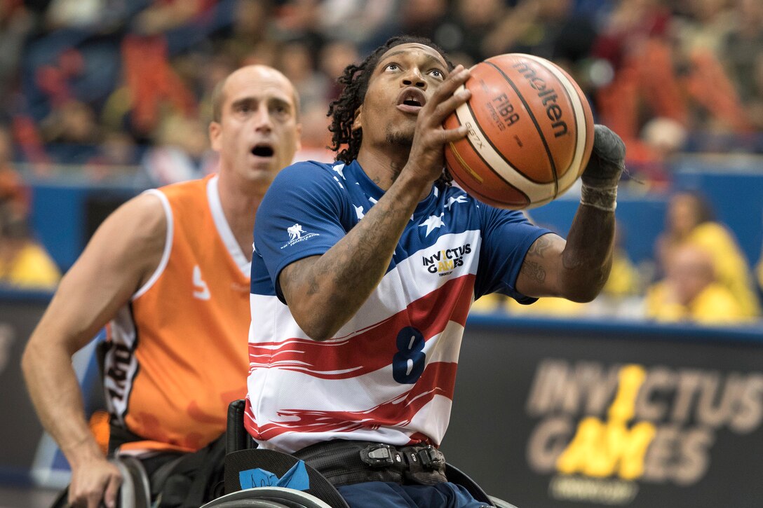Marine Corp Sgt. Anthony McDaniel takes a shot against Netherland defenders winning the gold medal wheelchair basketball game.