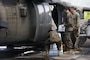 U.S. service members load water into a U.S. Army UH-60 Black Hawk helicopter