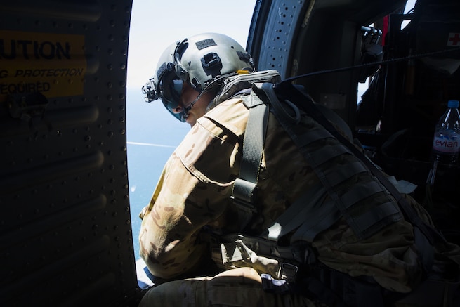 A Soldier looks out of the window of a UH-60 Black Hawk helicopter