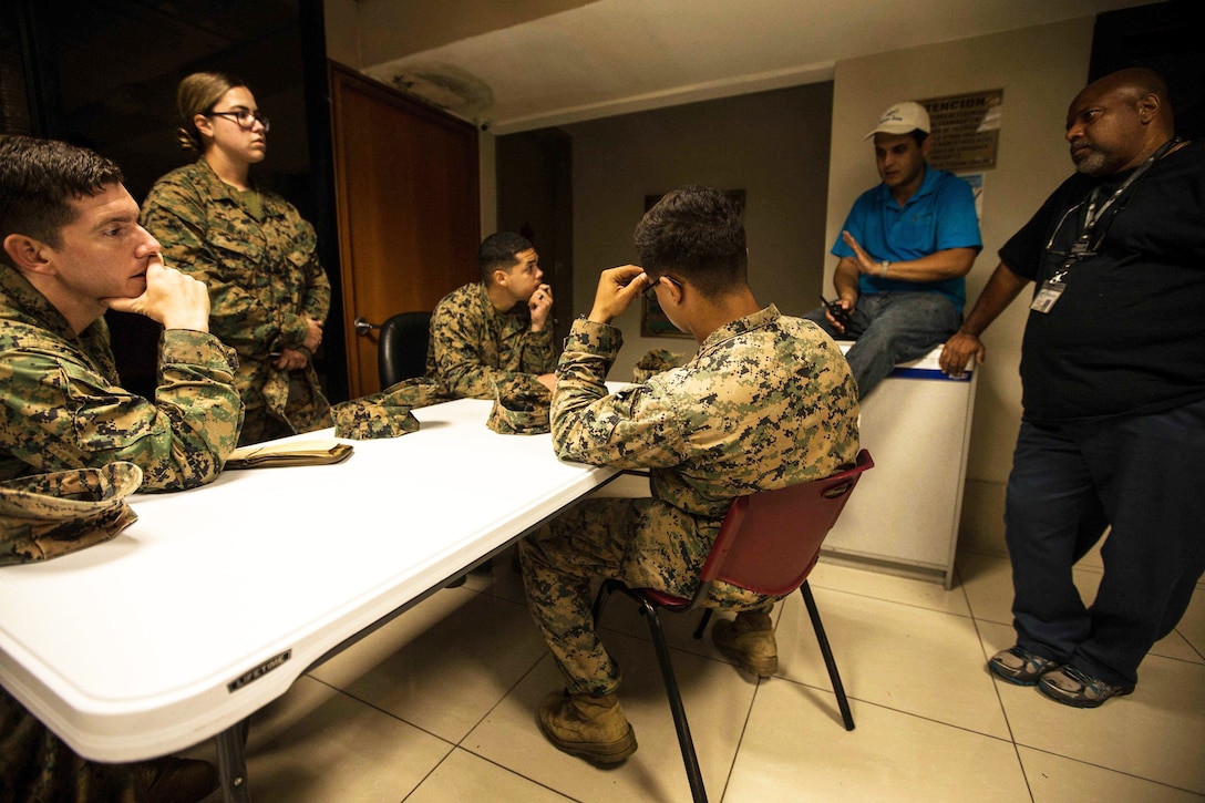 Marines, Navy sailors speak to officials at the hospital.