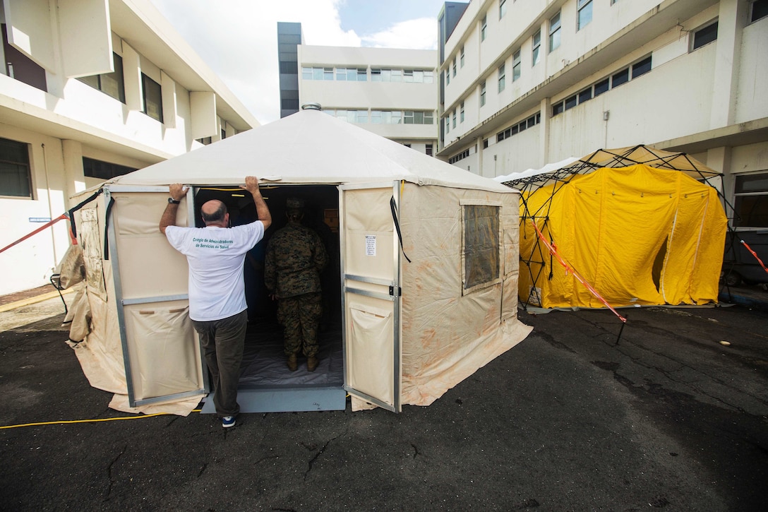 Military members inspect tents for possible surgeries.