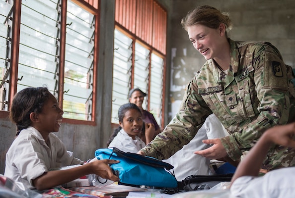 GLENO, Timor Leste (June 15, 2016) Spc. Kayla Sutton, a native of Lake Helen, Florida, assigned to USNS Mercy (T-AH 19), hands out basic hygiene kits to local Timorese children at the Dona Ana Lemos Escuela elementary school during a Pacific Partnership 2016 health outreach event. Service members donated supplies provided by Project Hand Clasp, and educated kids on preventative health measures for basic hand washing, oral hygiene, water safety and mosquito protection. Pacific Partnership 2016 marks the sixth time the mission has visited Timor Leste since its first visit in 2006. Medical, engineering and various other personnel embarked aboard hospital ship Mercy are working side-by-side with partner nation counterparts, exchanging ideas, building best practices and relationships to ensure preparedness should disaster strike. (U.S. Navy photo by Mass Communication Specialist 2nd Class William Cousins/Released)