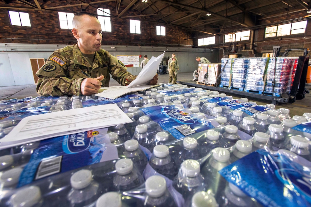 Army Capt. Michael Sojka reviews paperwork for supplies being shipped from the National Guard Armory in Lawrenceville.