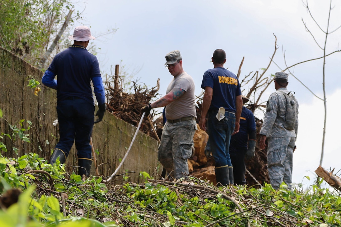 A group of people look at debris.