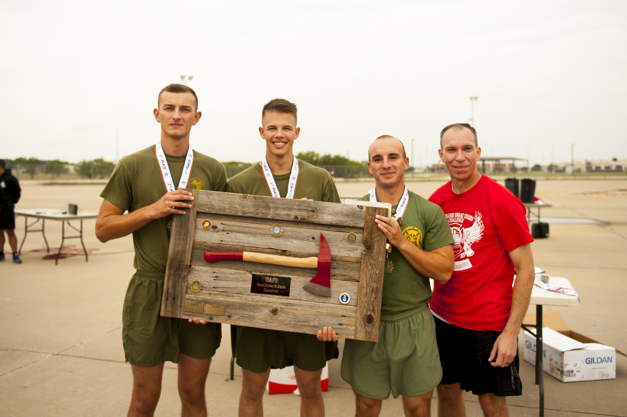 U.S. Marine Corps Lance Cpl. Zane Reece, Pfc. Christian Gender and Pfc. Tyler Mogul, 312th Training Squadron trainees, receive the first place plaque from U.S. Air Force Lt. Col. Scott Cline, 312th TRS commander, for winning the fourth annual Blood, Sweat and Stairs event at the Louis F. Garland Department of Defense Fire Academy on Goodfellow Air Force Base, Texas, Sept. 30, 2017. Each person competed on a team of three; the fastest won the event. (U.S. Air Force photo by Senior Airman Scott Jackson/Released)