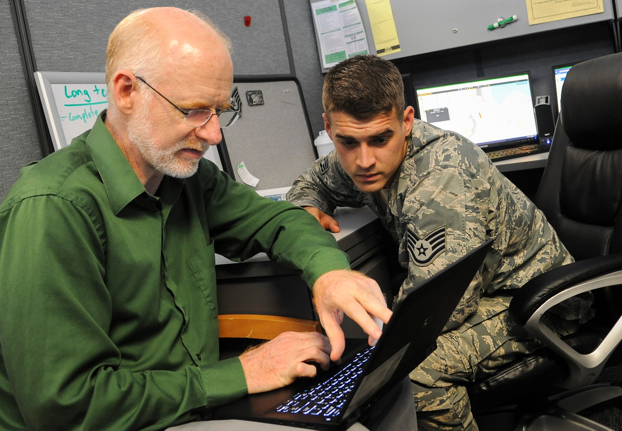 Staff Sgt. Joshua Modlin, assistant noncommissioned officer in charge of the 88th Security Forces Squadron's Electronic Security Systems (ESS), works with Joe Andrews of M.C. Dean, Inc. to establish a configuration baseline by ensuring the more than 16,000 ESS assets throughout Wright- Patterson Air Force Base, Ohio are accurately identified, Sept. 20,2107. Andrews helped to develop the Infrastructure Maintenance Management System (IMMS) being implemented throughout the Air Force to not only track maintenance of critical ESS infrastructure, but also help to identify trending problems and develop improvements that can be implemented enterprise wide. Andrews is part of the BCF Solutions team taking over the maintenance and management of Wright-Patt's ESS on Oct. 1. (U.S. Air Force photo/Jim Varhegyi)