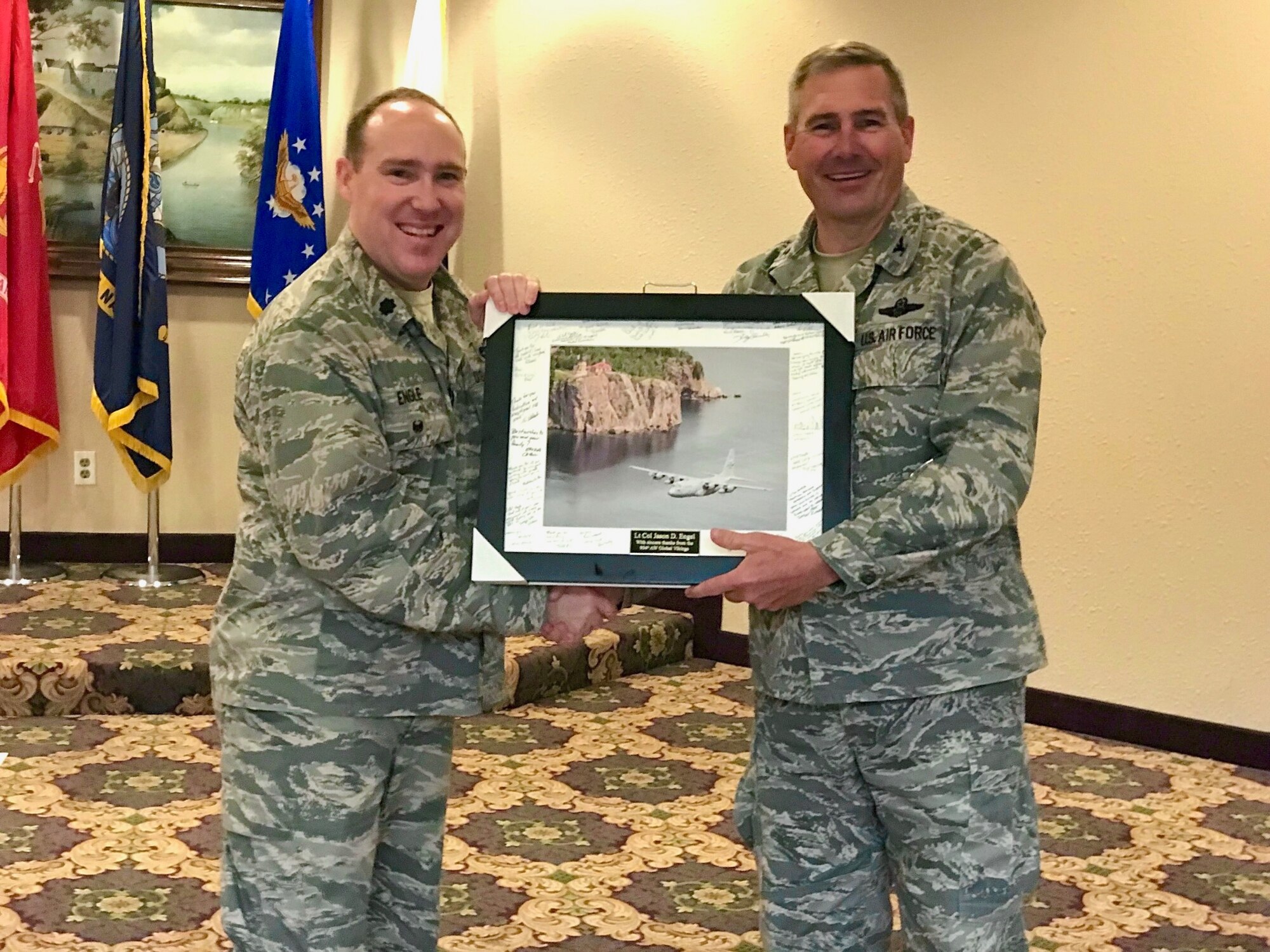 Lt. Col. Jason Engle, 934th Airlift Wing chief of inspections, accepts a farewell photo from Col. Tim Wollmuth, 934th Airlift Wing vice commander, Sept. 29.  Engle accepted a new position at Scott AFB, Illinois. (Air Force Photo/Paul Zadach)