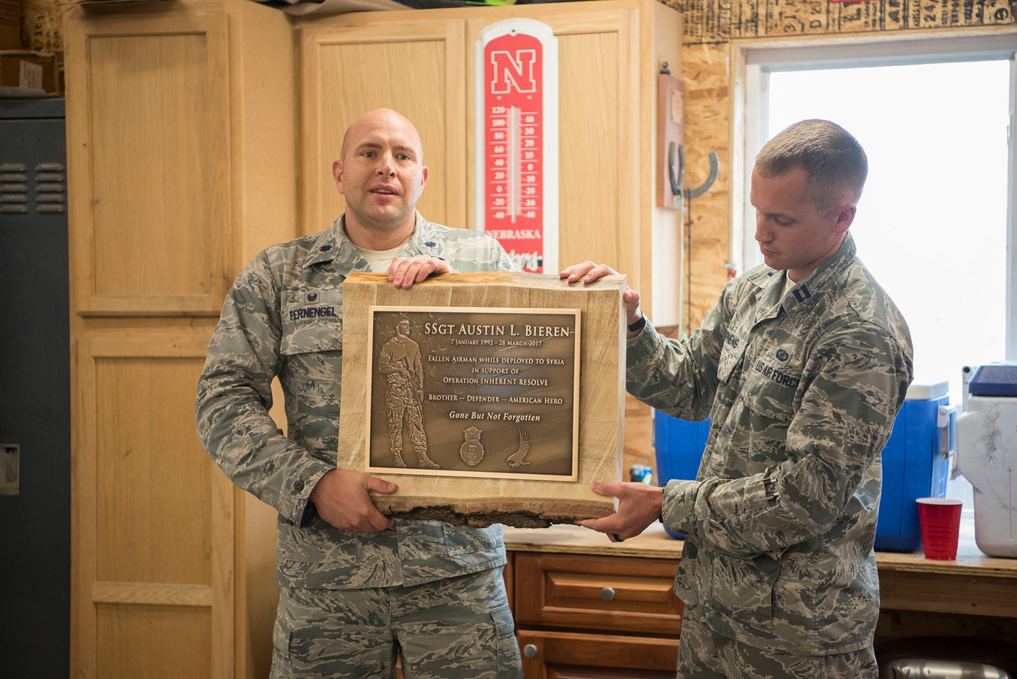 Lt.Col. Chris Fernengel, 4th Space Control Squadron commander (left) and Capt. Brett Stephens, 4th SPCS engineering flight commander current operations presented a plague during the weekly roll call for the 4th SPCS in Elbert, Colo. Sept. 28, 2017. The plaque will hang in the 4th SPCS building so that future squadron members can honor and pay their respects to Bieren. (U.S. Air Force Photo by Steve Kotecki)