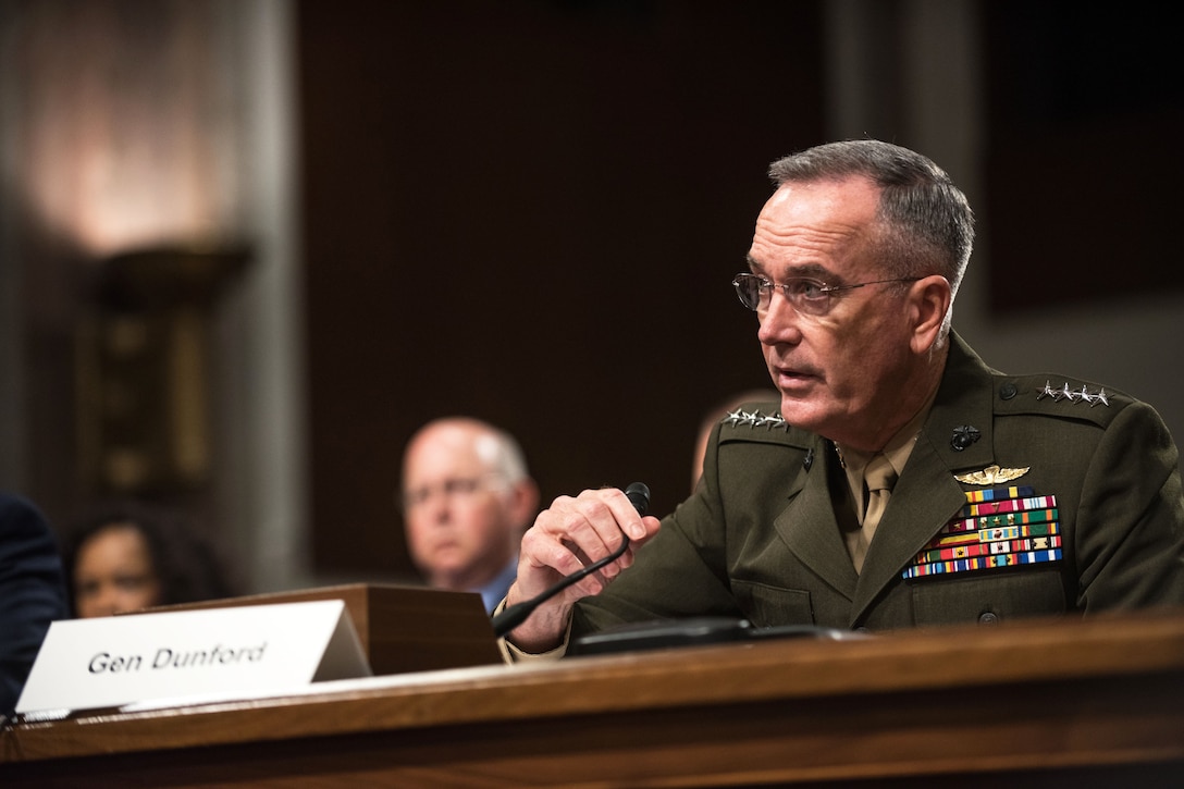 Dunford sits at a desk and speaks into a microphone.