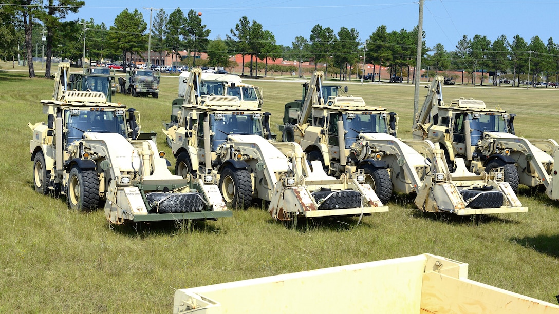 Guardsmen stage bulldozers and backhoes to be transported to Puerto Rico.