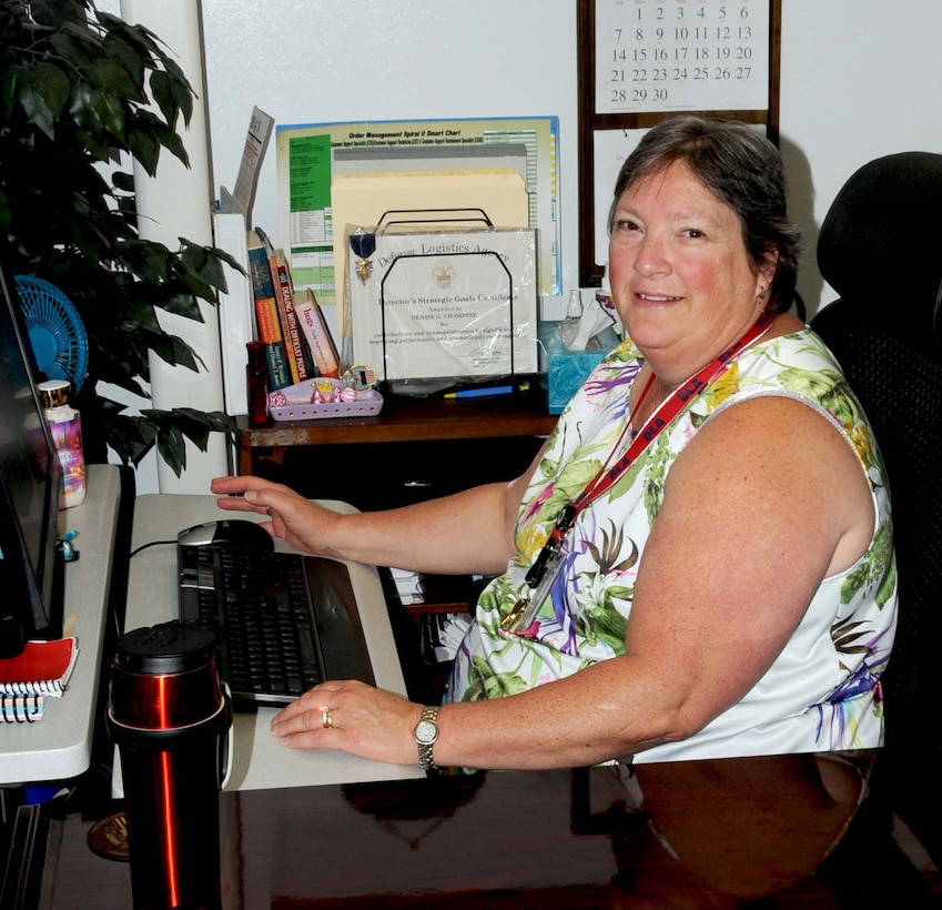 Denise Champine sits at her desk.