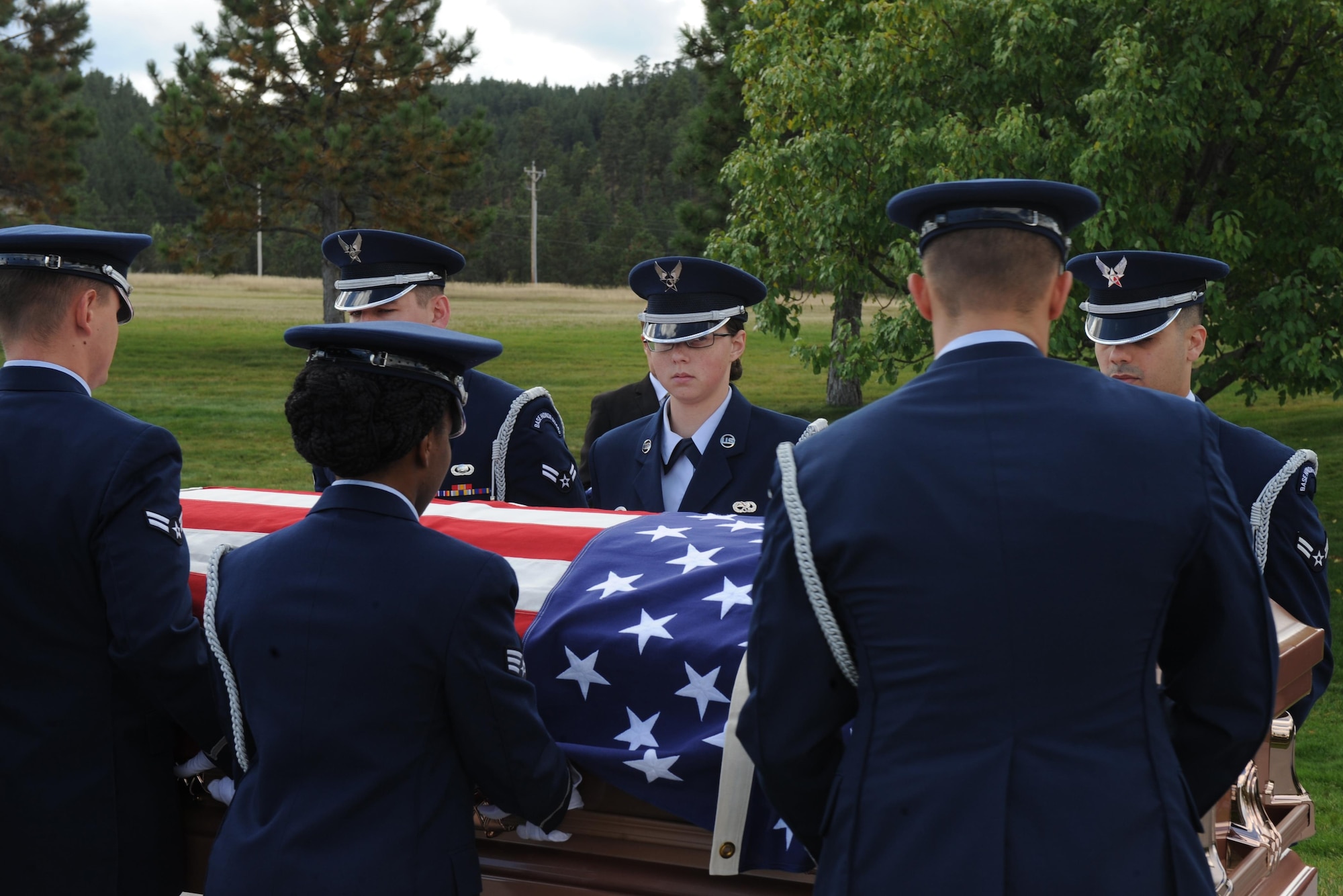 Airmen from the Ellsworth Air Force Base’s Honor Guard move the casket of a retiree during a funeral at Black Hills National Cemetery in Sturgis, S.D., Sept. 26, 2017. The funeral detail for pallbearers is comprised of a handoff to take the casket, a carry, a mark, a cross-mark, a fold and a noncommissioned officer in charge of the pallbearers to lead the team through the detail. (U.S. Air Force photo by Airman Nicolas Z. Erwin)