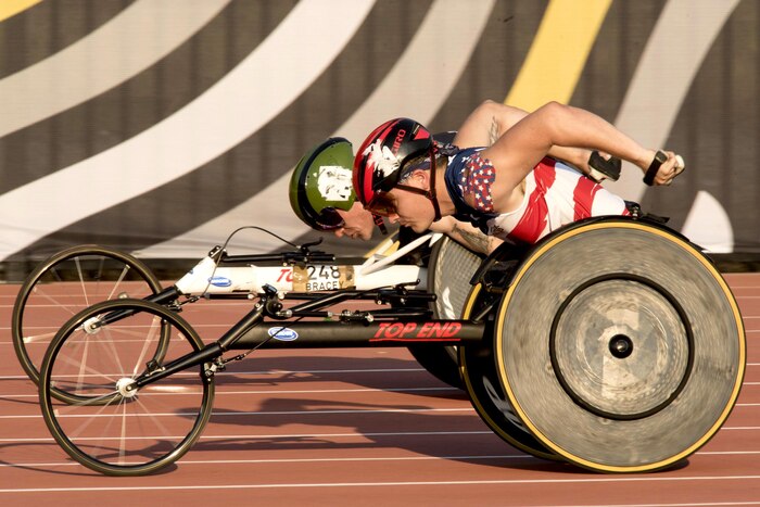 A Team U.S. member passes a Team Great Britain member in a wheelchair race.