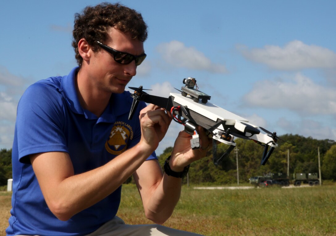 A U.S. Research Laboratory employee inspects a 3D printed unmanned aerial system vehicle after it landed during a demonstration at Camp Lejeune, N.C., Sept. 26, 2017. The UAS vehicles are designed to cater to individual missions based on distance, endurance, and carrying capacity needs. By creating a system that is easier to set up and more cost effective than traditional UAS devices, the U.S. Army Research Laboratory hopes to revolutionize the way troops conduct assignments.(U.S. Marine Corps Photo by Lance Cpl. Gloria Lepko)