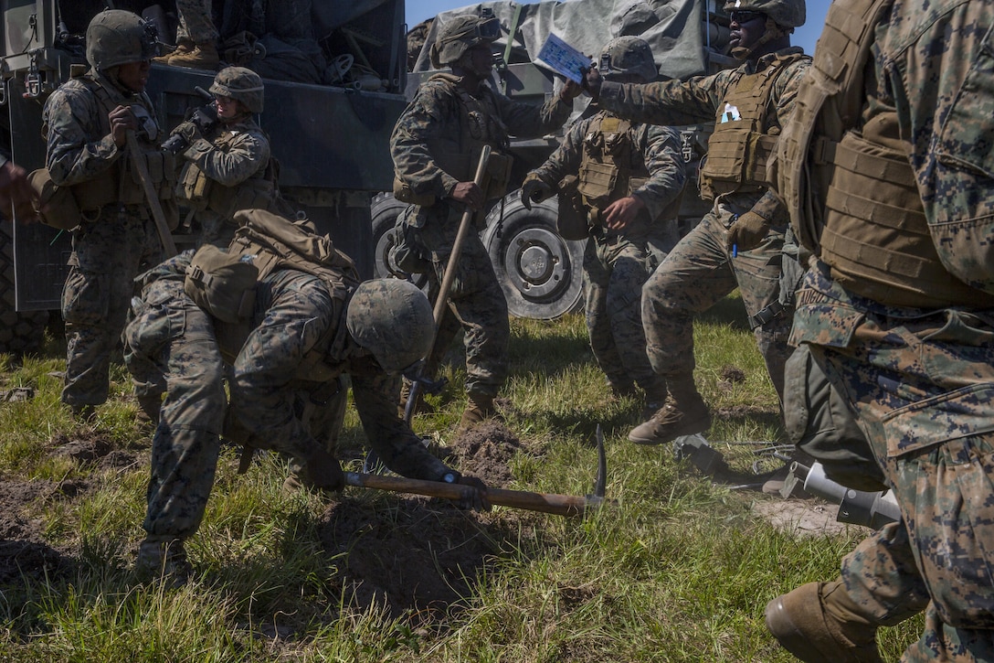 Marines dig holes to emplace an M777 howitzer during a Marine Corps Combat Readiness Evaluation at Camp Lejeune, N.C., Sept. 28, 2017. The Marines conducted the MCCRE to maintain readiness for future operations. The Marines are with 1st Battalion, 10th Marine Regiment. (U.S. Marine Corps photo by Lance Cpl. Taylor W. Cooper)