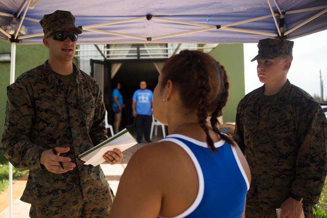 Two marines speak to a civilian.