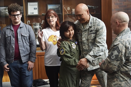 Sandrea Hershey, center left, 14 years old, hugs and thanks Col. Jimmy Canlas, center right, 437th Airlift Wing commander, for hosting her during an Airman for a Day event here, Oct. 2, 2017. The event was hosted by the 628th Air Base Wing and 437th AW.  Hershey was diagnosed with cancer in 2015 and spent approximately 170 days in a hospital. Despite her diagnosis Hershey kept up with her school work and finished her final treatment last month. Sandrea, her mother Lori Hershey, and her friend Justin Pippin, also 14 years old, met 628th Security Forces Squadron Phoenix Raven members, observed a military working dog demonstration, toured a C-17 Globemaster III with Airmen from the 14th Airlift Squadron and tested their piloting skills in a C-17 flight simulator. (U.S. Air Force photo by Staff Sgt. Christopher Hubenthal)