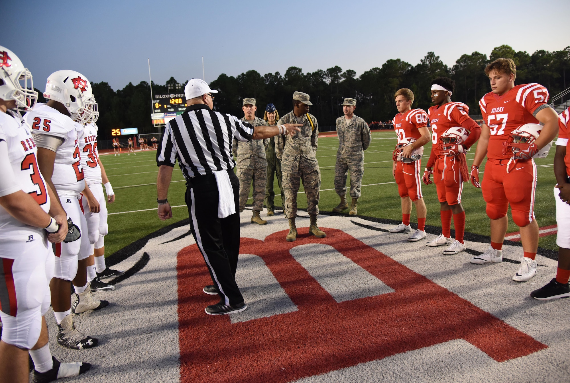 Keesler leadership and personnel participate in a coin toss ceremony during the Biloxi High School military appreciation night football game Sept. 29, 2017, Biloxi, Mississippi. Keesler leadership participated in the coin toss to determine which team would receive the ball first. (U.S. Air Force photo by Kemberly Groue)