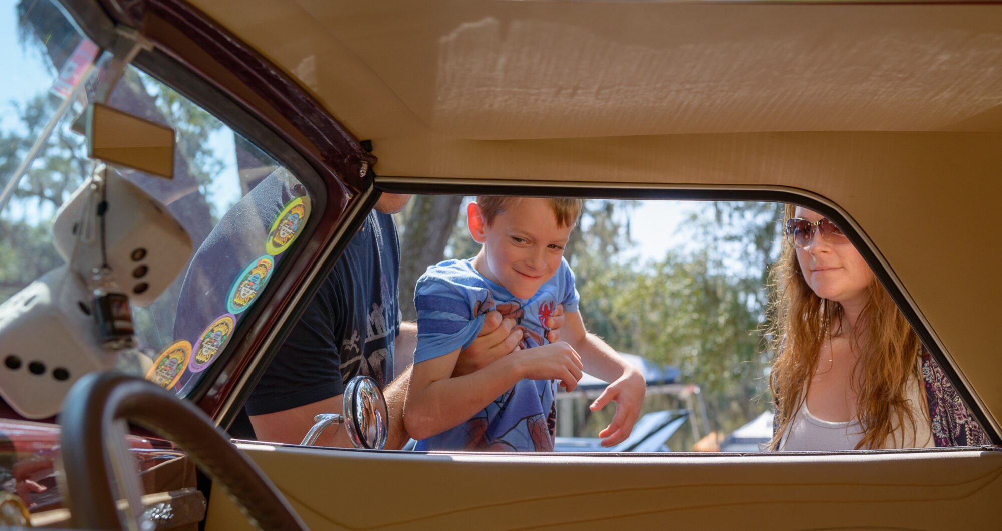 Jaxon Dean, son of Master Sgt. Charles Dean, 81st Medical Support Squadron information flight chief, and his mother, Jessica Dean, look inside of a 1937 Chevy Cabriolet at The Marina Park during the 14th Annual Cruisin’ Keesler Car Show Sept. 30, 2017, on Keesler Air Force Base, Mississippi. The annual car show is held to kick off Cruisin’ the Coast, a festival to celebrate classic cars, trucks and hot rods, where vehicles cruise down the 30-mile beachside highway in Mississippi. There were over 300 visitors and 130 classic vehicle entries with 15 awards presented. (U.S. Air Force photo by Andre’ Askew)