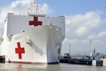 The hospital ship USNS Comfort, white with red crosses, is docked in Puerto Rico