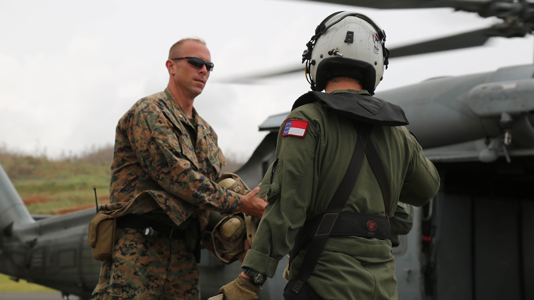 U.S Marine Maj. Robert Gill, the officer in charge of Joint Task Force - Leeward Island’s security element, gathers flight helmets from a U.S. sailor with Helicopter Sea Combat Squadron 22 to give to U.S. citizens departing Dominica at Charles-Douglas Airport in Melville Hall, Dominica, Sept. 25, 2017. Gill and his Marines provide security and stability at landing zones and at the U.S. Department of State’s evacuation control center at the airport. At the request of partner nations and both the Department of State and the U.S. Agency for International Development, JTF-LI has deployed aircraft and service members to areas in the eastern Caribbean Sea affected by hurricanes Irma and Maria. The task force is a U.S. military unit composed of Marines, Soldiers, Sailors and Airmen, and represents U.S. Southern Command’s primary response to both disasters. (U.S. Army photo by Capt. Trisha Black)