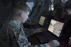 A Marine looks at a computer screen