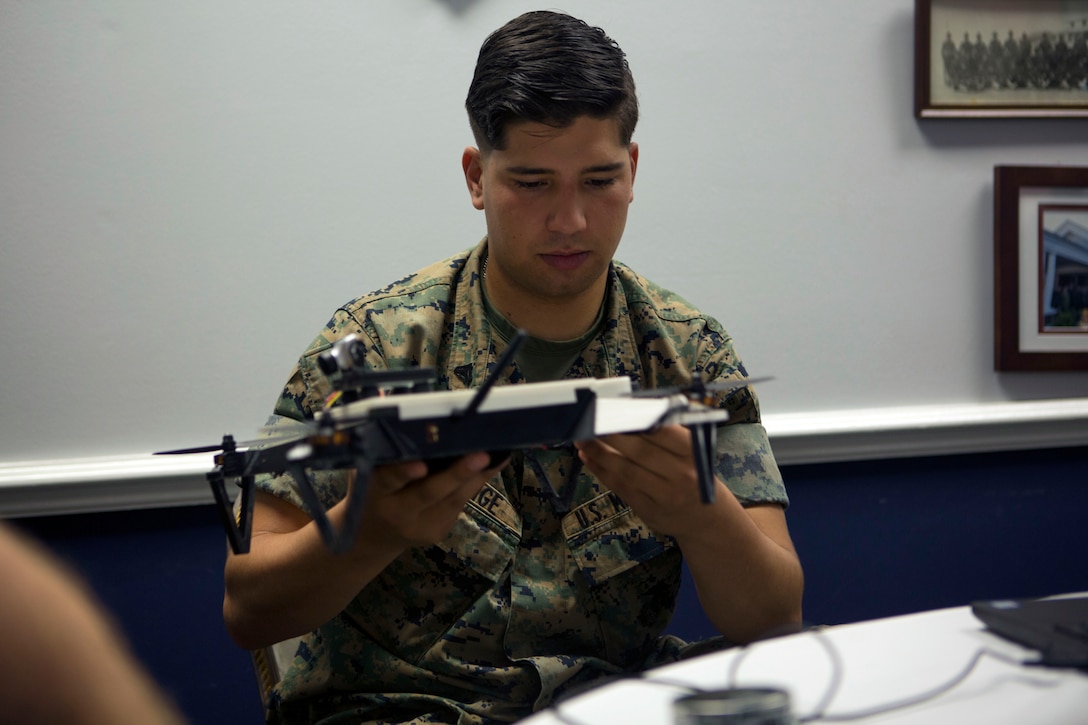 A Marine holds an aircraft in his hands.