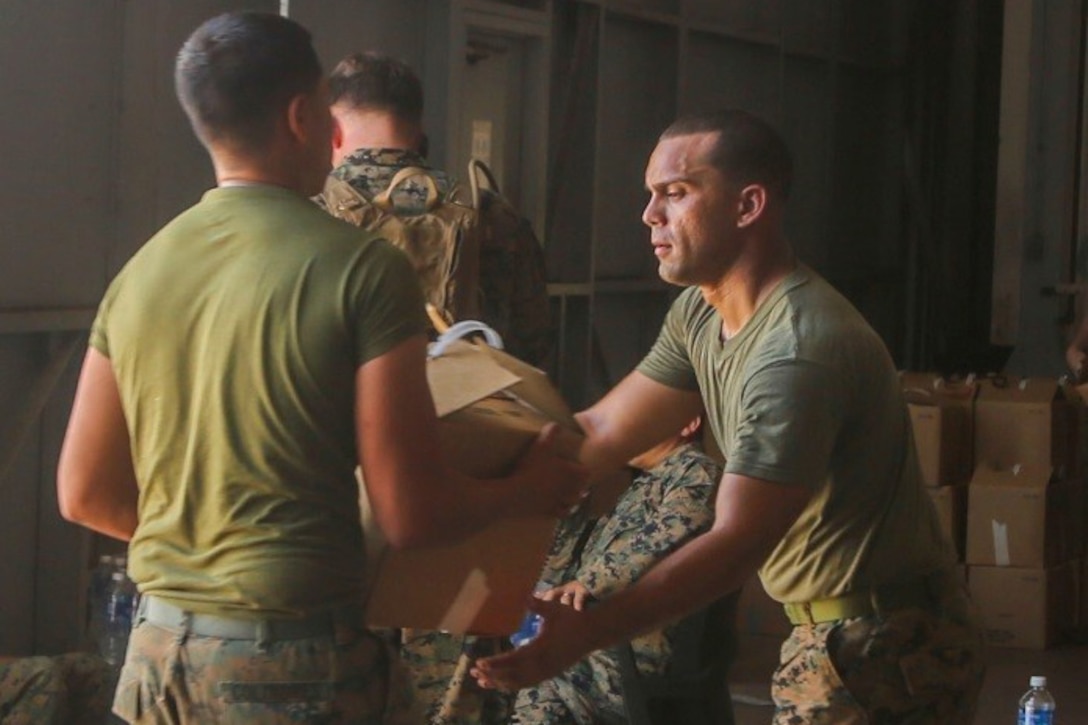 Marines unload hurricane relief supplies.