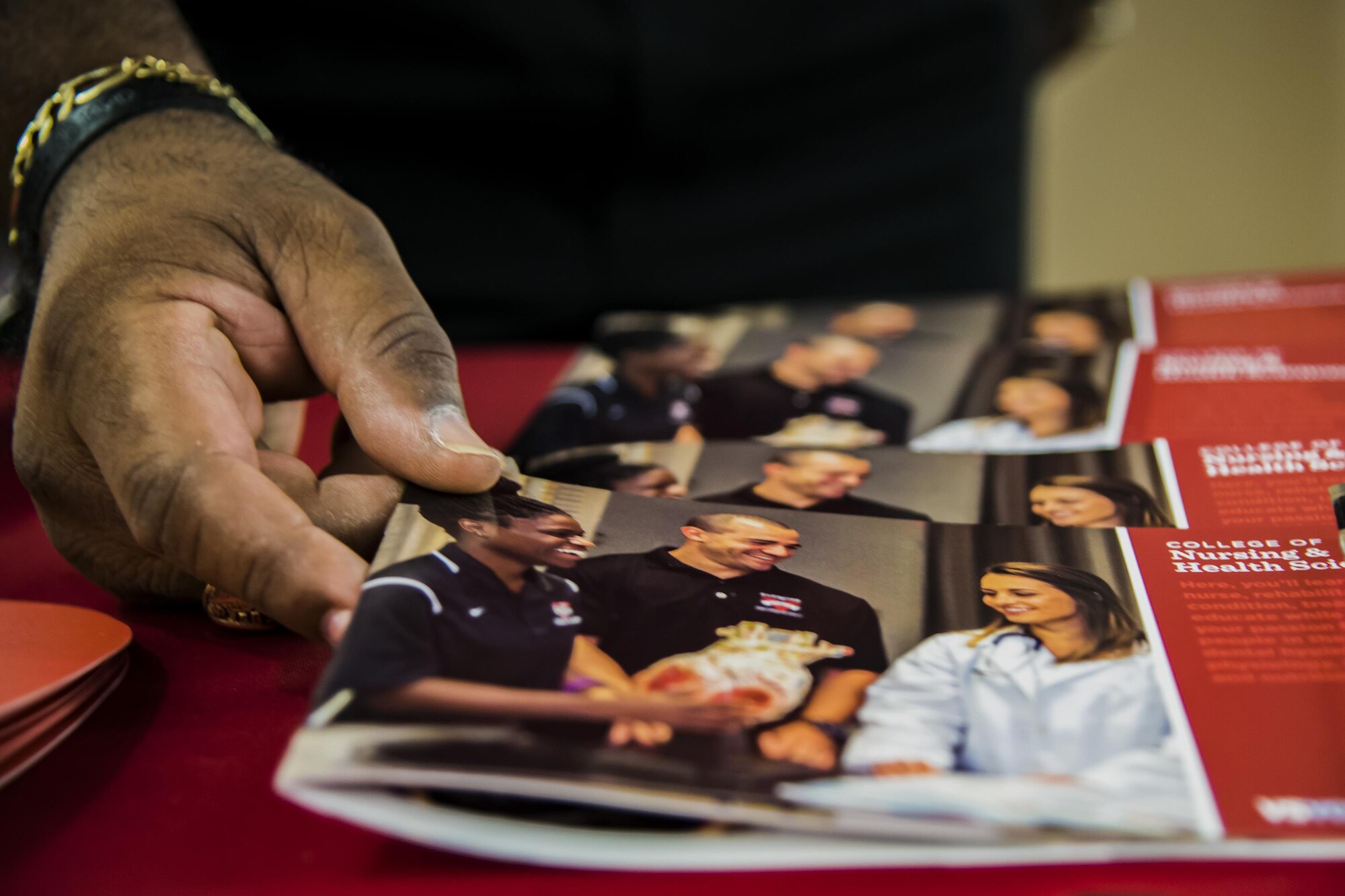 An information pamphlet is picked up during a National Education Fair, Oct. 3, 2017, at Moody Air Force Base, Ga. The event allowed Team Moody to learn about higher education opportunities that they have access to. (U.S. Air Force photo by Airman Eugene Oliver)